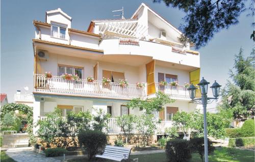 - un bâtiment blanc avec un balcon et un éclairage de rue dans l'établissement Cozy Apartment In Brodarica With Wifi, à Brodarica