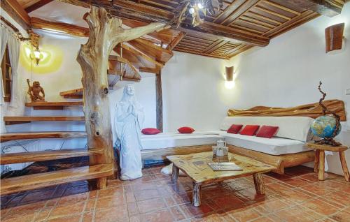 a living room with a tree and a bed and a table at One-Bedroom Holiday Home In Donja Voca in Gornja Voća