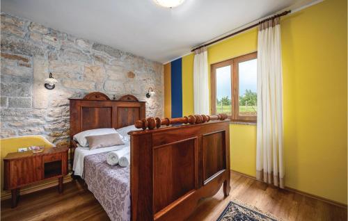 a bedroom with a bed and a stone wall at Amazing Apartment In Baderna With 3 Bedrooms, Wifi And Outdoor Swimming Pool in Baderna