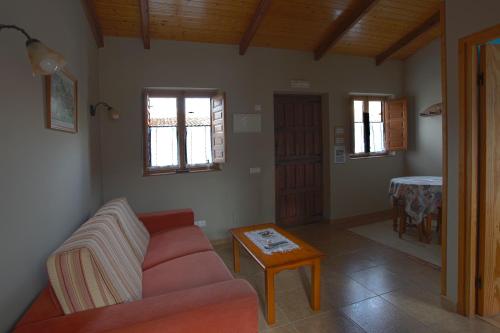 a living room with a red couch and a table at Apartamentos El Campal in Felechosa