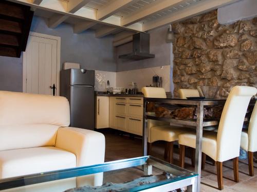 a kitchen with a table and chairs and a stone wall at Casa Rural La Ardina in Sotres