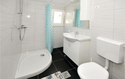 a white bathroom with a toilet and a sink at Lovely Apartment In Kastel Kambelovac With Wifi in Kaštela