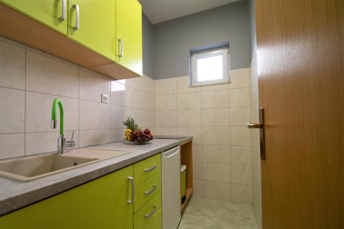 a kitchen with a sink and a window at Apartments Hudovernik in Baška Voda