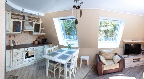 a kitchen and dining room with a table and chairs at Nidos Ilsė in Nida