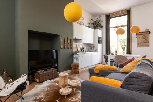 a living room with a couch and a tv at Cosy Nock ! Little Gem at City Center with Large Terrace ! in Breda
