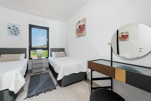 a bedroom with two beds and a mirror and a desk at Apartment MaLu in Banjole