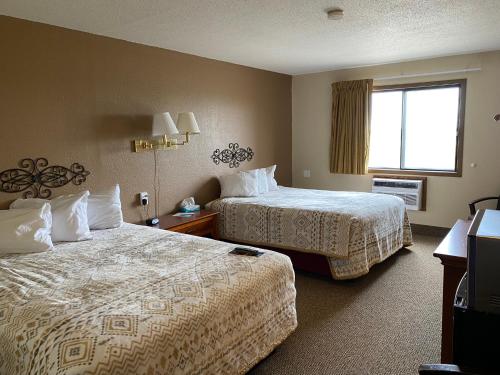 a hotel room with two beds and a window at Americas Best Value Inn Kadoka in Kadoka