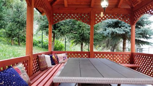 a wooden table in a gazebo with pillows at Apartments Town Center in Sarajevo