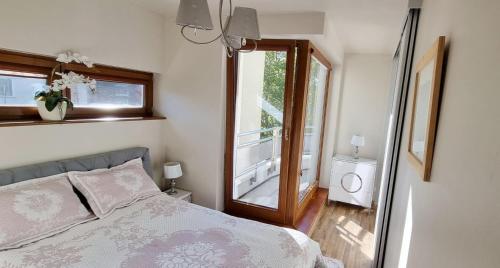 - une chambre avec un lit et une grande fenêtre dans l'établissement Apartament Perła Juraty, à Jurata