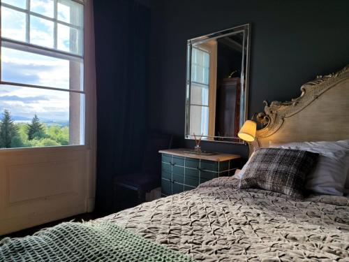 a bedroom with a bed with a mirror and a window at Glencruitten House in Oban