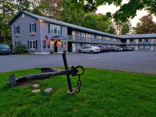 a bench in the grass in front of a building at Anchorage Motel in Bar Harbor