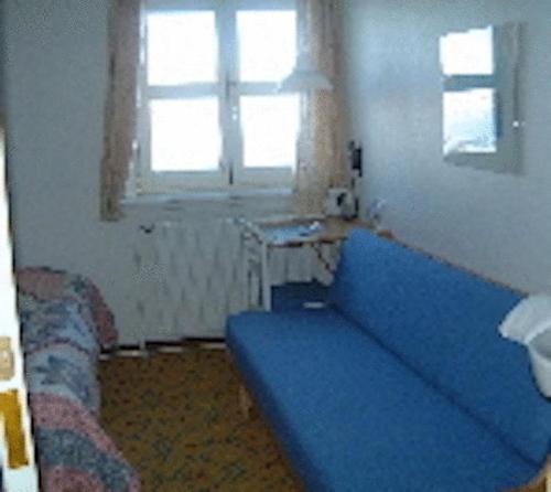 a blue couch in a room with a window at Hotel Angmagssalik in Tasiilaq