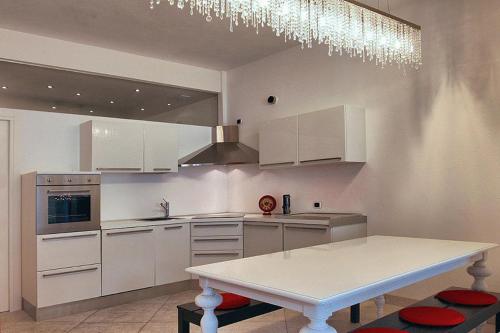 a kitchen with white cabinets and a white table at Villa Maggie on Lake Como in Malgrate