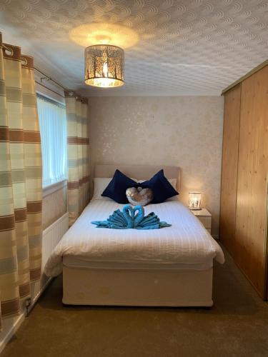a bedroom with a white bed with blue pillows at Dunfermline, 2 bedroom home free on street parking in Fife