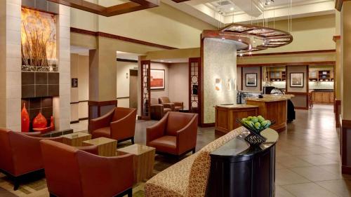 a lobby of a hotel with chairs and a fireplace at Sonesta Select Tucson Airport in Tucson