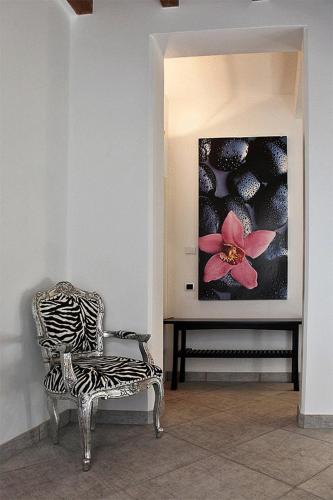 a room with a chair and a painting on the wall at Villa Maggie on Lake Como in Malgrate