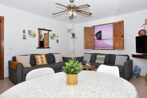 sala de estar con sofá y mesa en Ático con encanto en Cabo de Gata. A 100m de la playa., en Carboneras
