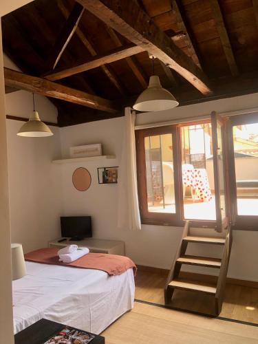 a bedroom with a bed and a chair and a window at Apartamento Canónigo - terraza con vistas in Toledo