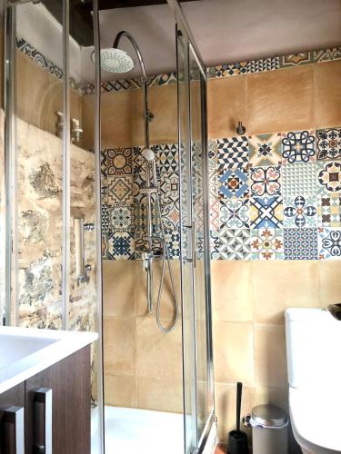 a bathroom with a shower with tiles on the wall at Apartamento Canónigo - terraza con vistas in Toledo