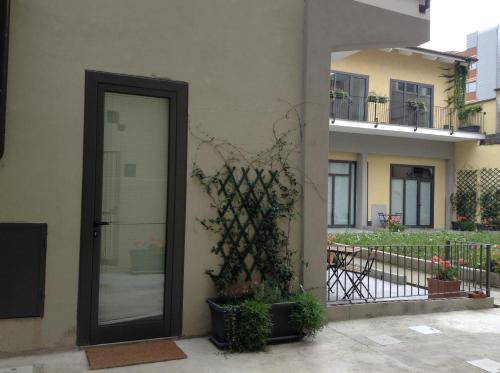 a door to a building with a plant next to it at Loft Regio Parco in Turin
