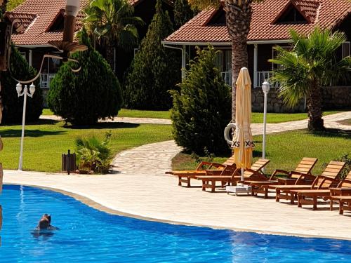 uma pessoa na piscina de um resort em Club Sun Village Hotel em Adrasan