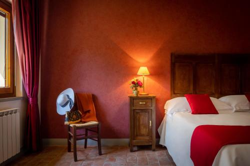 a bedroom with a bed and a chair and a lamp at Tenuta Risalpiano in Pelago