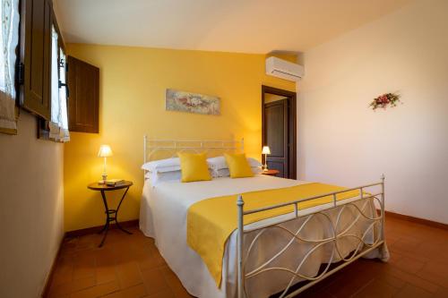 a bedroom with a large bed with yellow walls at Tenuta Risalpiano in Pelago