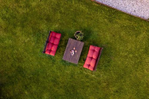 PelagoにあるTenuta Risalpianoの赤い椅子2脚と芝生の上のテーブル