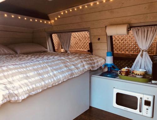 LandrumにあるVan Camping - Do Something Different!のベッドルーム1室(ベッド1台付)、電子レンジ付きのカウンター