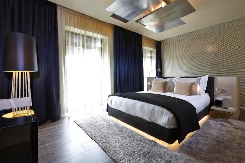 a bedroom with a large bed and a large window at 9Hotel Mercy in Lisbon