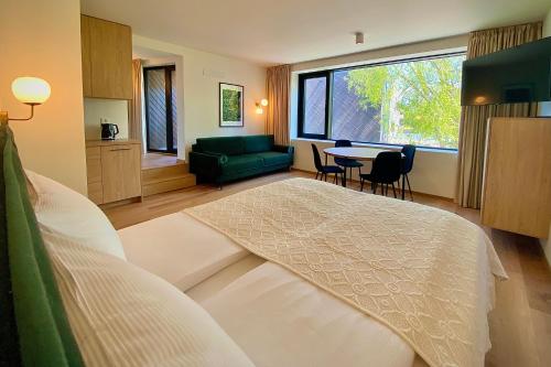 a bedroom with a bed and a couch and a table at SIRENA in Palanga