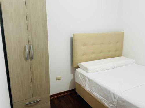 a small bedroom with a bed and a cabinet at Apartamento en el Centro de Trujillo - Primer Piso in Trujillo