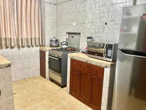 a small kitchen with a stove and a microwave at Apartamento en el Centro de Trujillo - Primer Piso in Trujillo