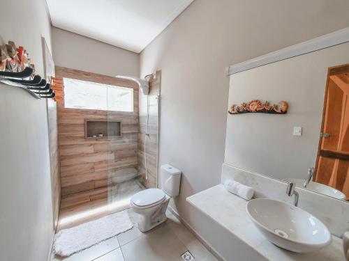 uma casa de banho branca com um WC e um chuveiro em Pousada NAK - Nativa Arpoador Kite em Tutóia