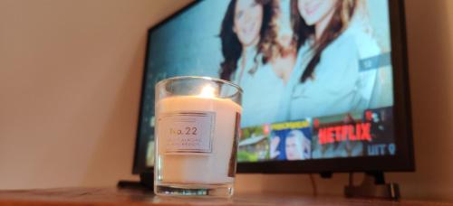 a candle sitting on a table in front of a television at 'Neasa' Luxury Double Bedroom in Foxford