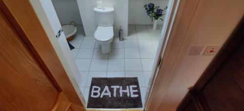 a bathroom with a toilet and a rug on the floor at 'Neasa' Luxury Double Bedroom in Foxford