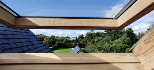 a window on the roof of a house with trees at 'Neasa' Luxury Double Bedroom in Foxford