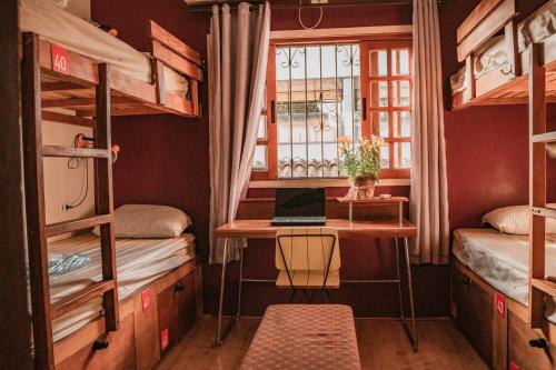 a room with a desk and a laptop on a table at Garoa Hostel Party Bar in Sao Paulo