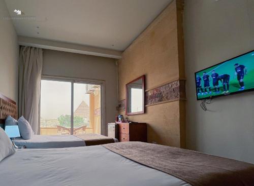 a hotel room with two beds and a flat screen tv at Giza Pyramids View Inn in Cairo