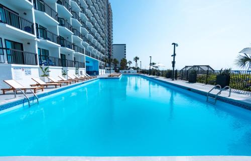 a large pool with blue water in a building at Grande Beach Resort in Myrtle Beach