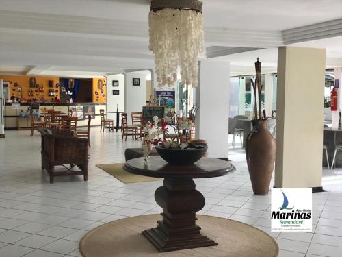 a lobby with a table in the middle of a building at Apart Hotel Marinas Tamandaré in Tamandaré