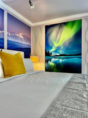 a bedroom with a bed with a wall mural of the northern lights at Sunshine Cottage in Talkeetna