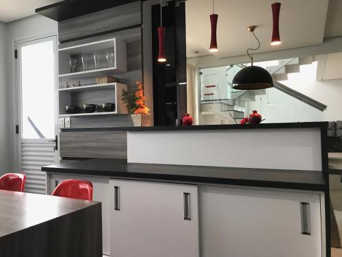 a kitchen with white cabinets and a black counter top at Conforto entre a UFSM e o centro in Santa Maria