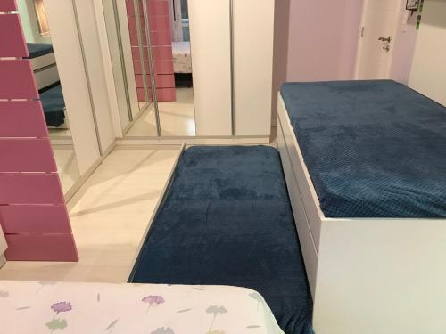 two beds in a room next to a mirror at Conforto entre a UFSM e o centro in Santa Maria