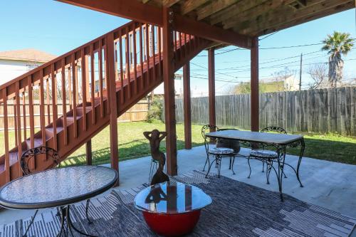 a patio with tables and chairs and a table with a table at PERFECT location spacious yard coffee bar at this lovely beach home in Galveston