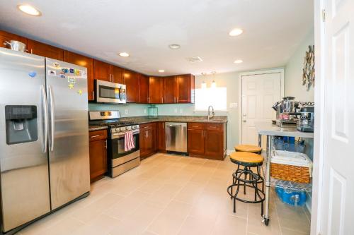 a kitchen with wooden cabinets and a stainless steel refrigerator at PERFECT location spacious yard coffee bar at this lovely beach home in Galveston