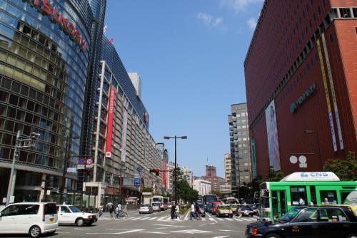 a busy city street with cars and people crossing the street at Stay Airport in Fukuoka