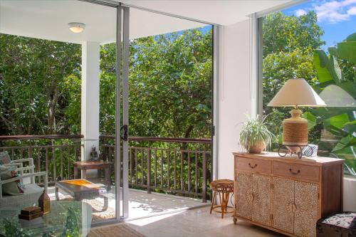 an open living room with a sliding glass door at 241 Santai - Balinese Resort Apartment by uHoliday in Casuarina