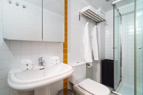een witte badkamer met een wastafel en een toilet bij El Palmeral I in Denia