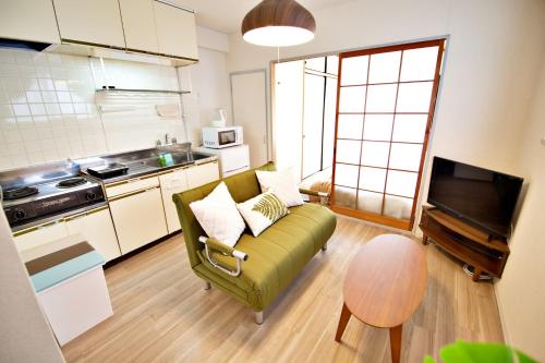 a living room with a green couch in a kitchen at Crest YS Chiyoda 7C in Aoichō